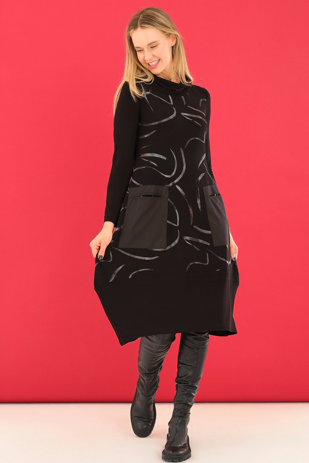 Woman wearing a black dress with abstract patterns against a red background