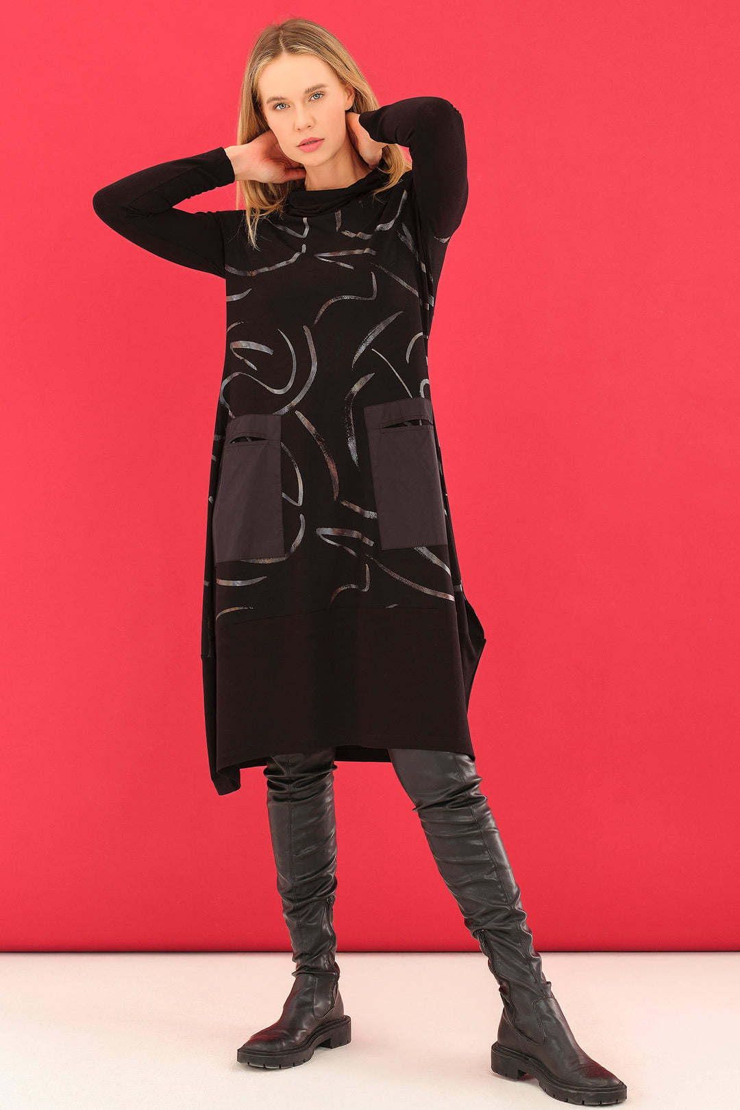 Woman wearing a black dress with abstract patterns against a red background