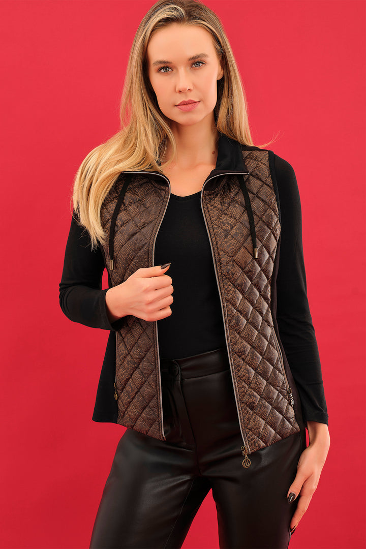 Woman wearing a quilted vest over a black top and pants on a red background