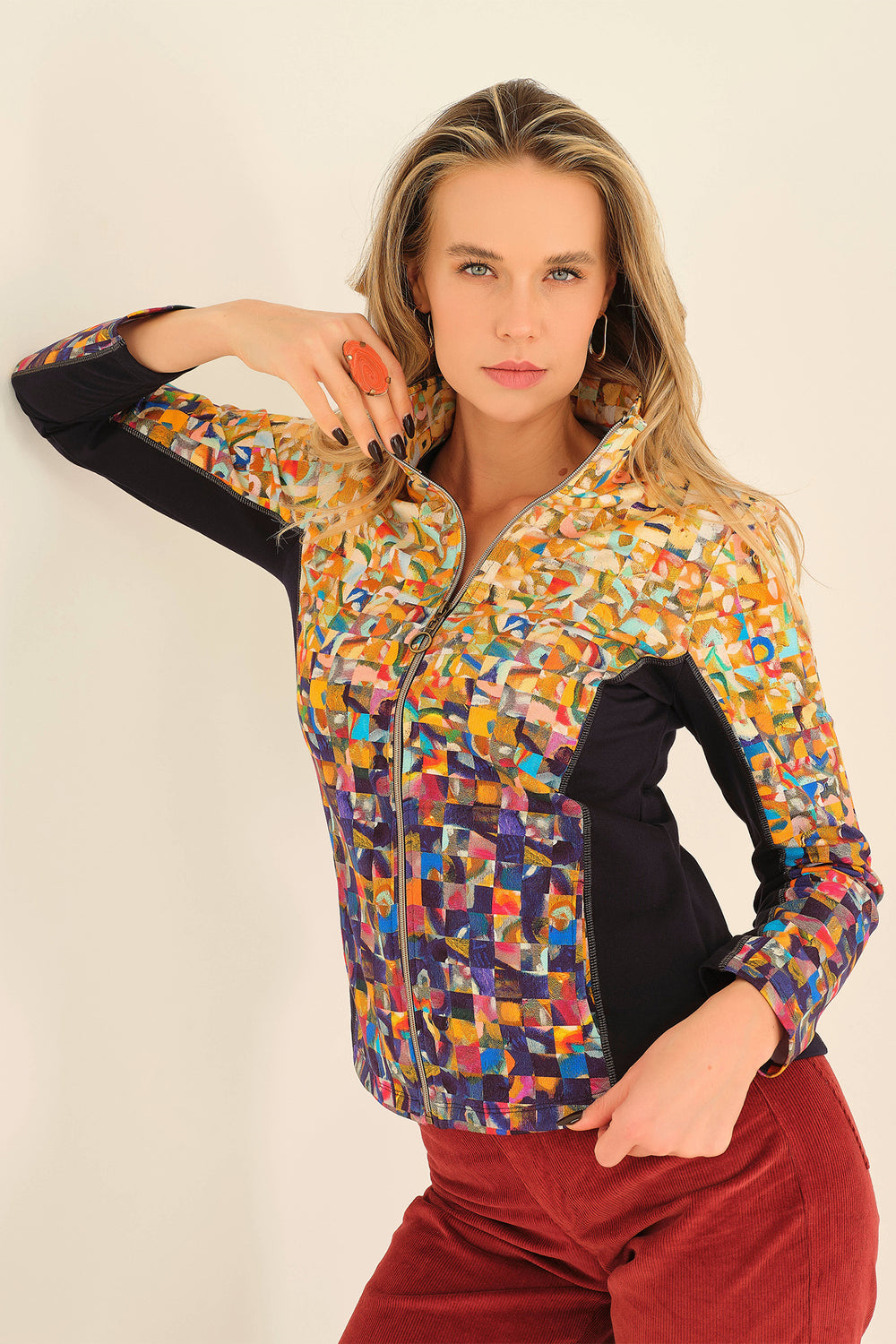 Woman wearing a colorful patterned jacket on a plain background