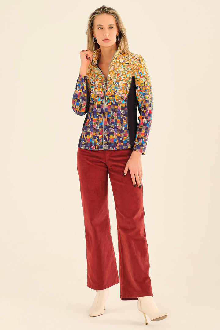 Woman wearing a colorful patterned blouse and red pants on a beige background