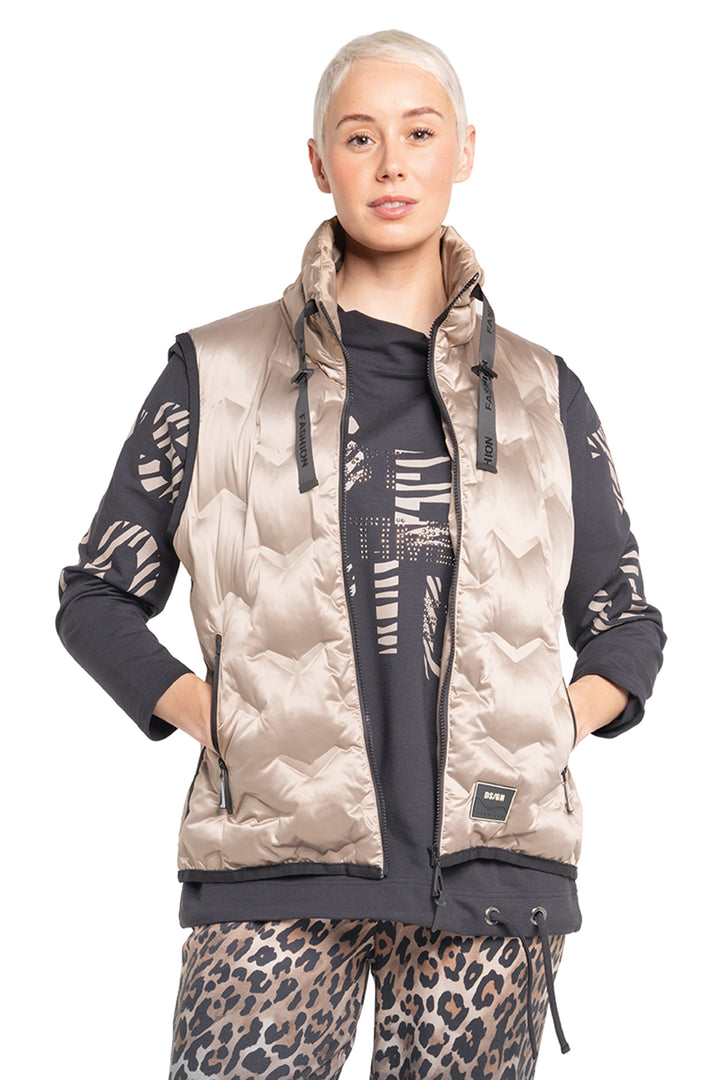 Person wearing a patterned jacket with leopard print pants on a white background