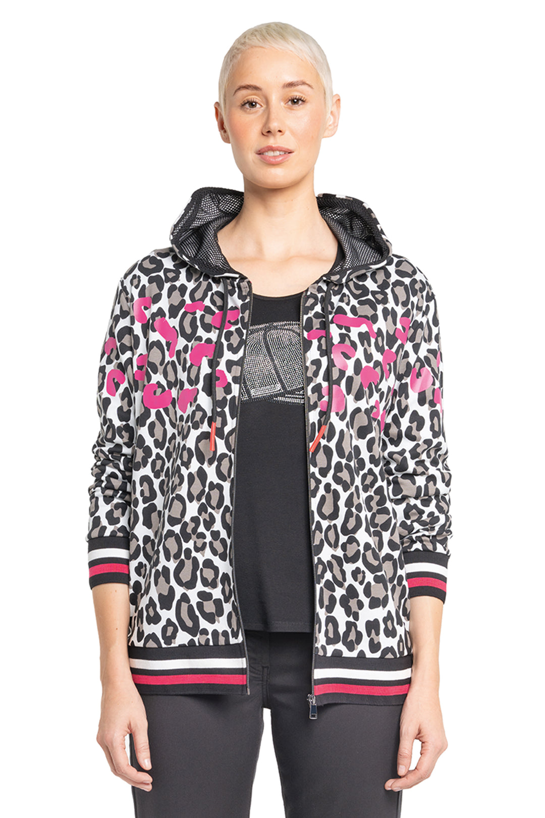 Woman wearing a leopard print jacket with pink accents on a white background
