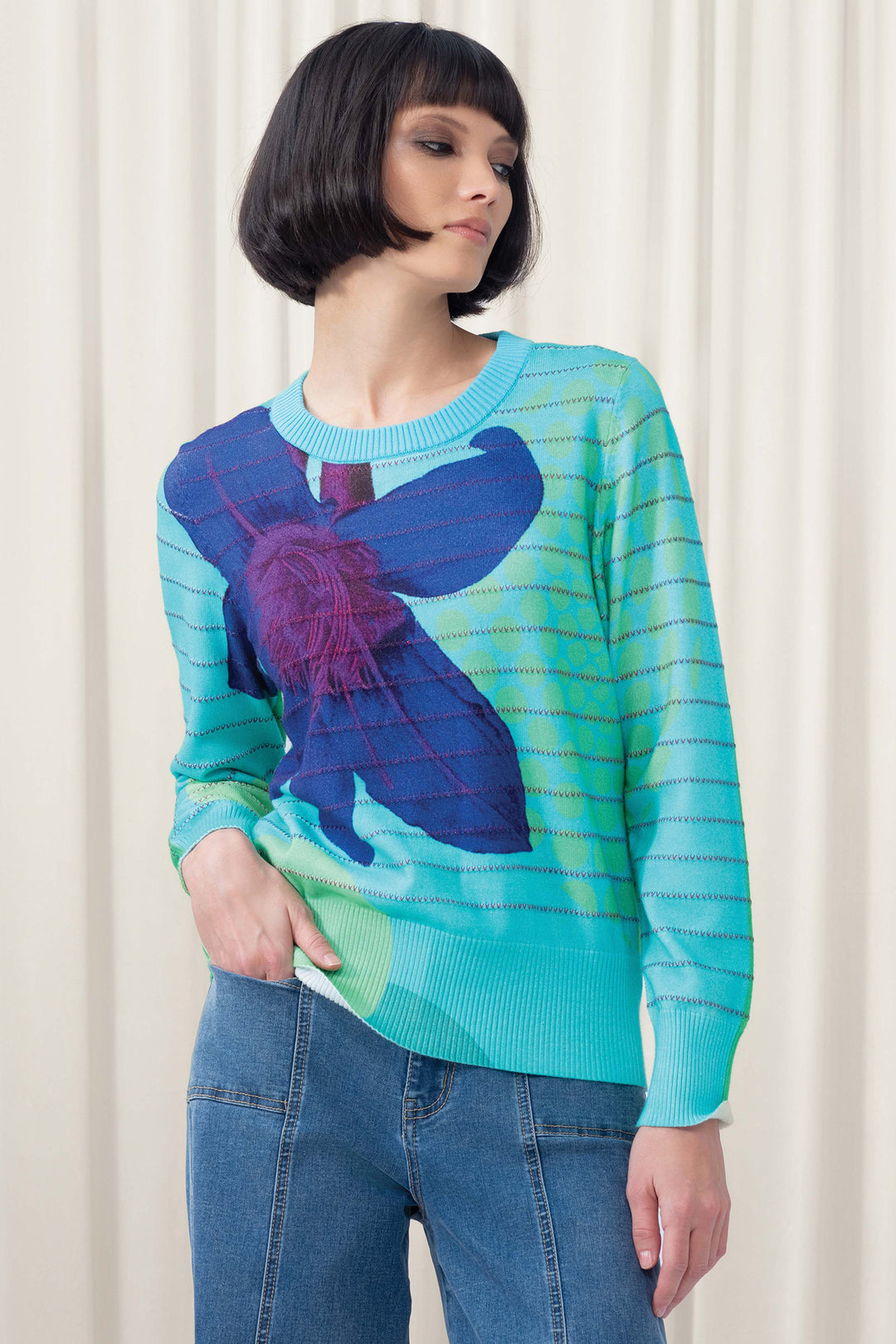 Person wearing a colorful sweater with a butterfly design against a white background