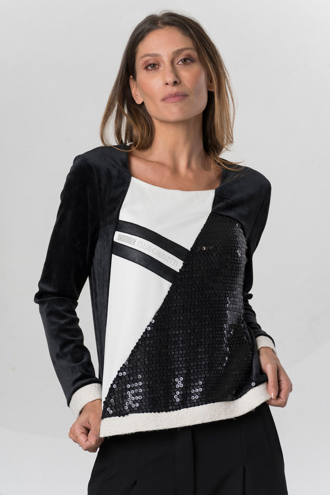 Woman wearing a black and white patterned top on a light gray background