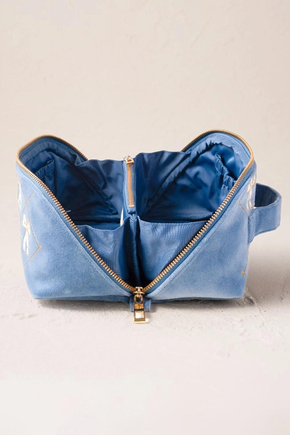 Blue bag with gold zippers on a light background