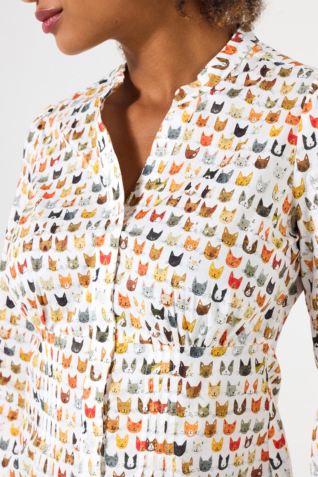 Patterned shirt with cat design worn by a person