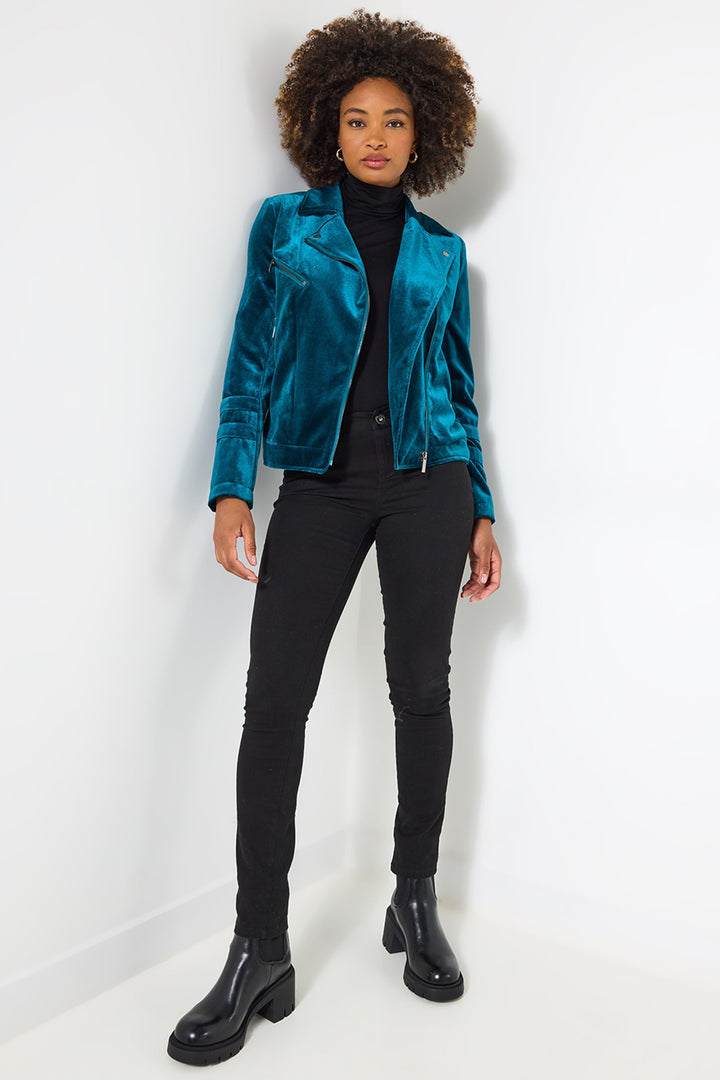 Person wearing a teal jacket, black turtleneck, black pants, and black shoes on a white background