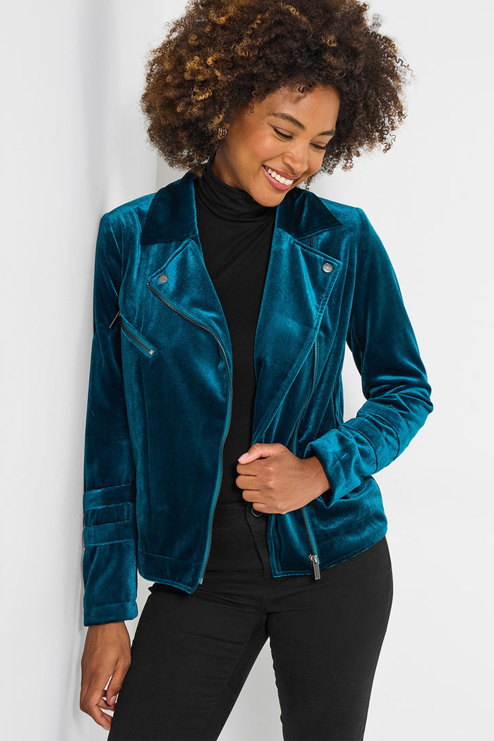 Woman wearing a teal velvet jacket on a white background