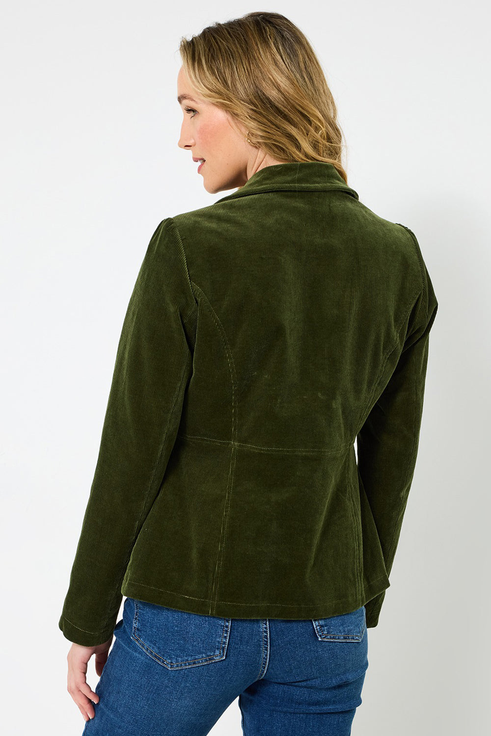 Woman wearing a green jacket and blue jeans on a white background
