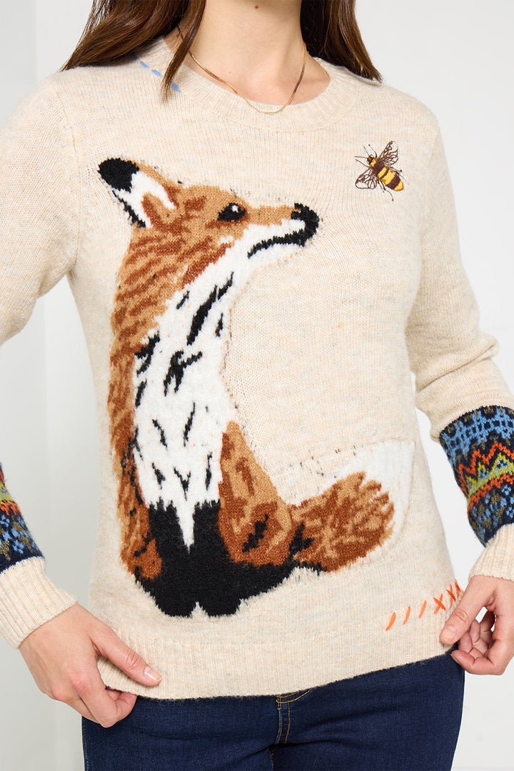 Person wearing a sweater with a fox design on a plain background