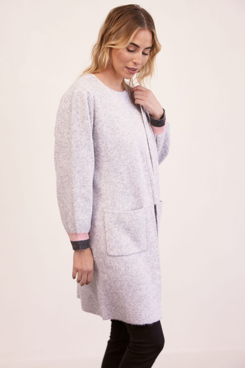 Woman wearing a light gray long coat on a white background