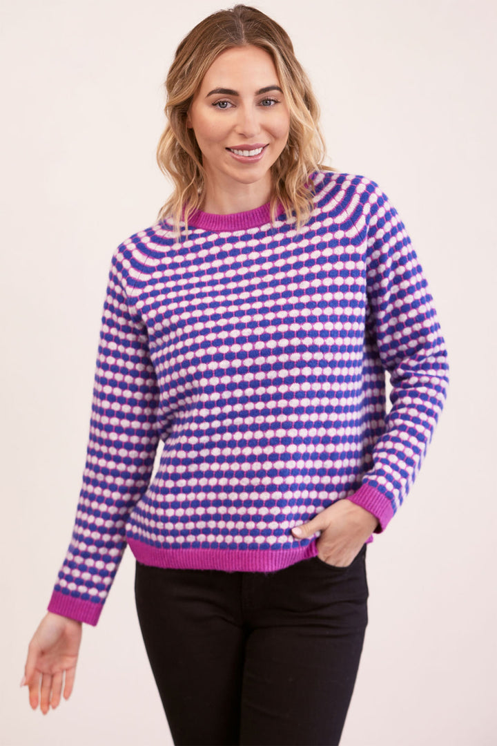 Woman wearing a purple and white checkered sweater on a beige background