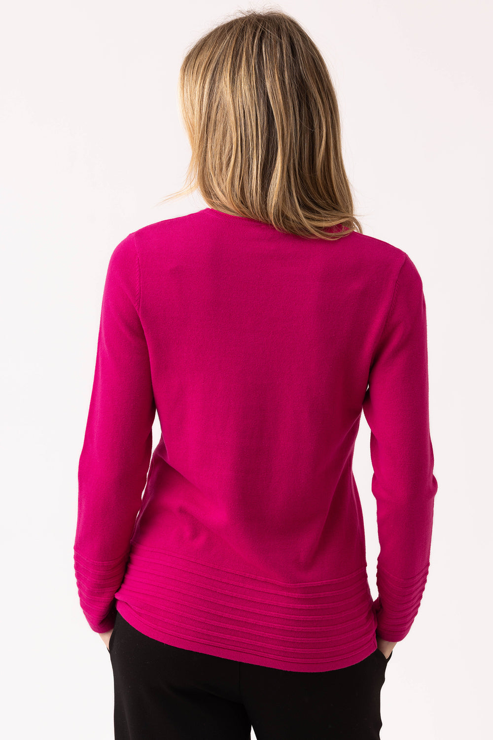 Person wearing a bright pink long-sleeve top on a white background