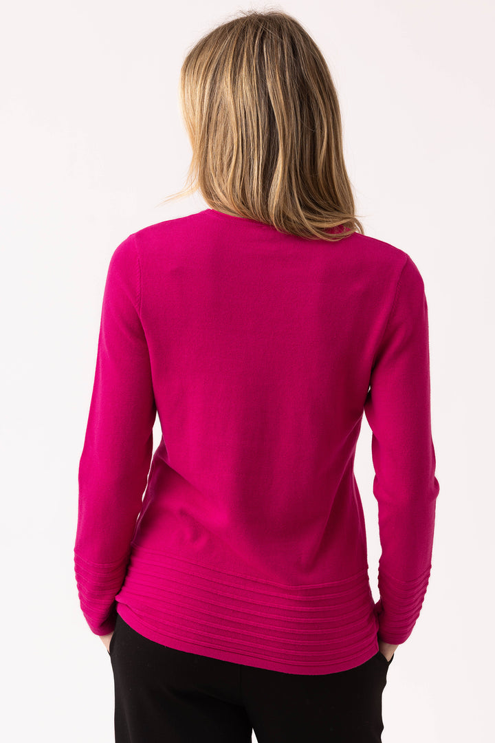 Person wearing a bright pink long-sleeve top on a white background