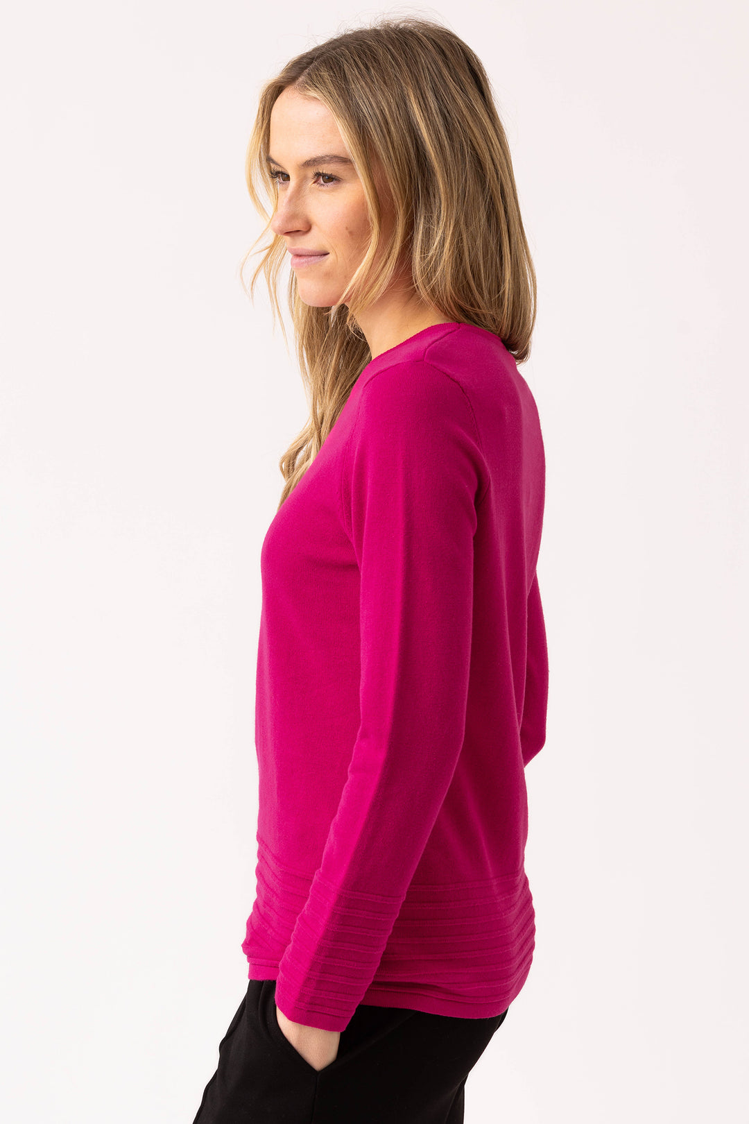 Woman wearing a bright pink long-sleeve top on a white background
