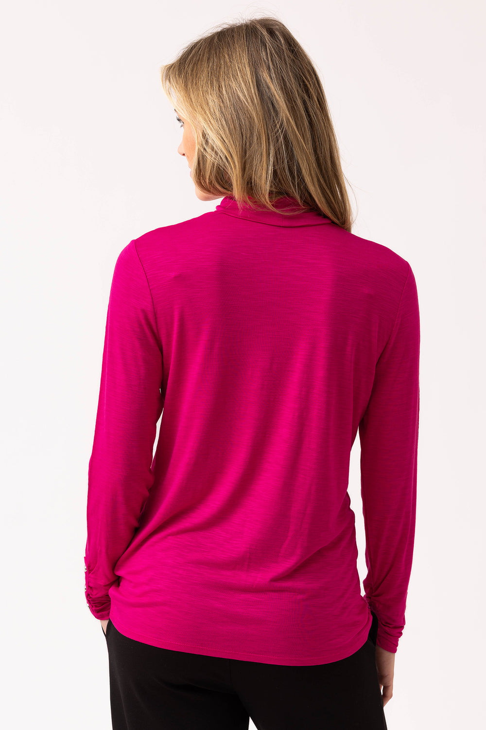 Person wearing a bright pink long-sleeve top on a white background