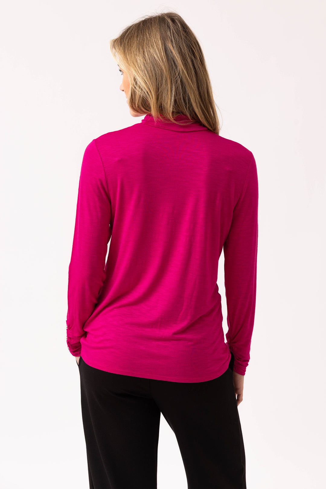 Person wearing a bright pink long-sleeve top on a white background