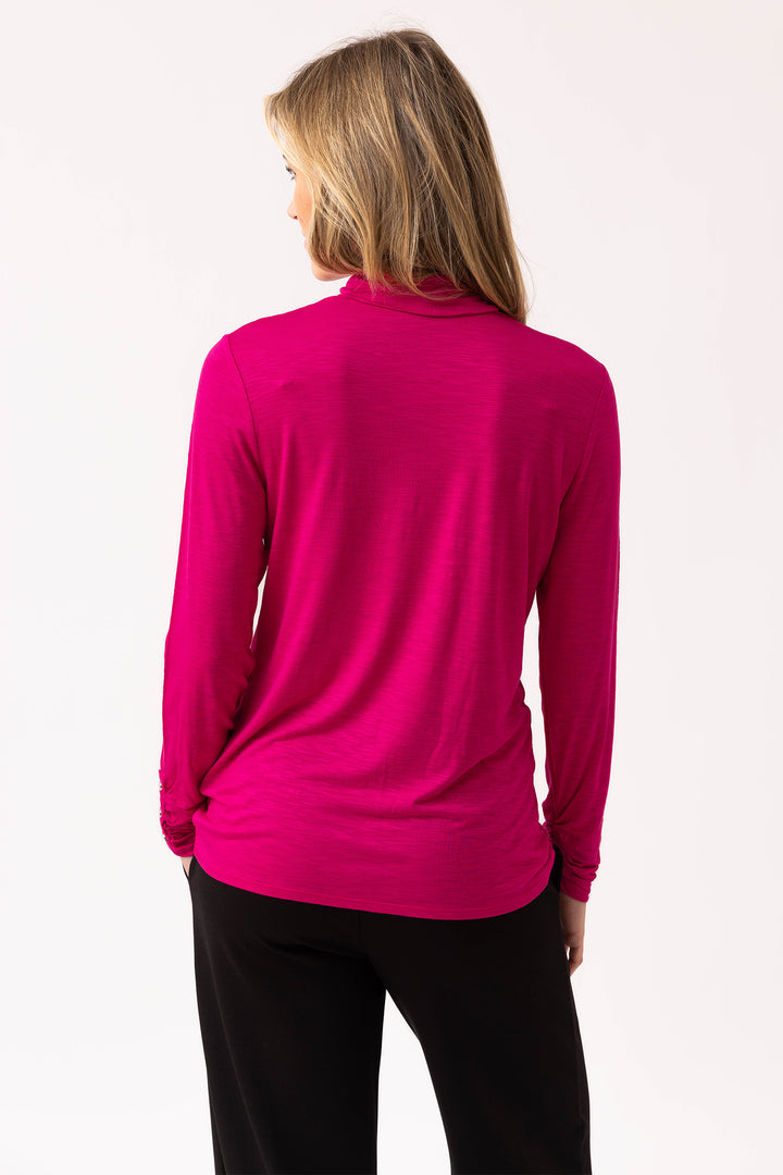 Person wearing a bright pink long-sleeve top on a white background