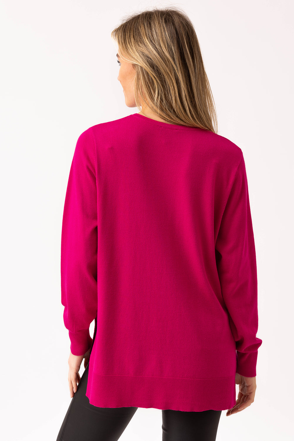 Woman wearing a bright pink sweater on a white background