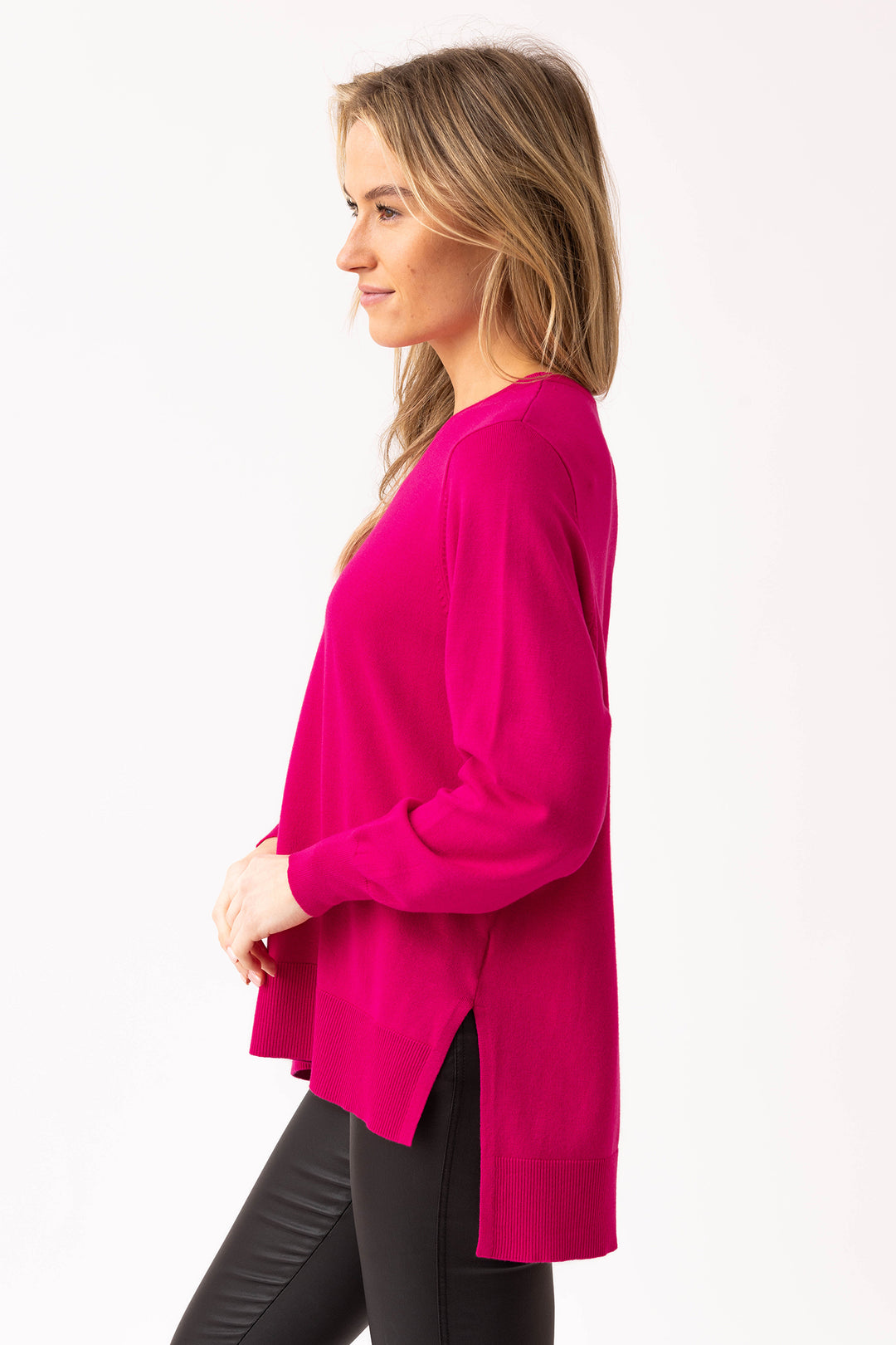 Woman wearing a bright pink cardigan on a white background