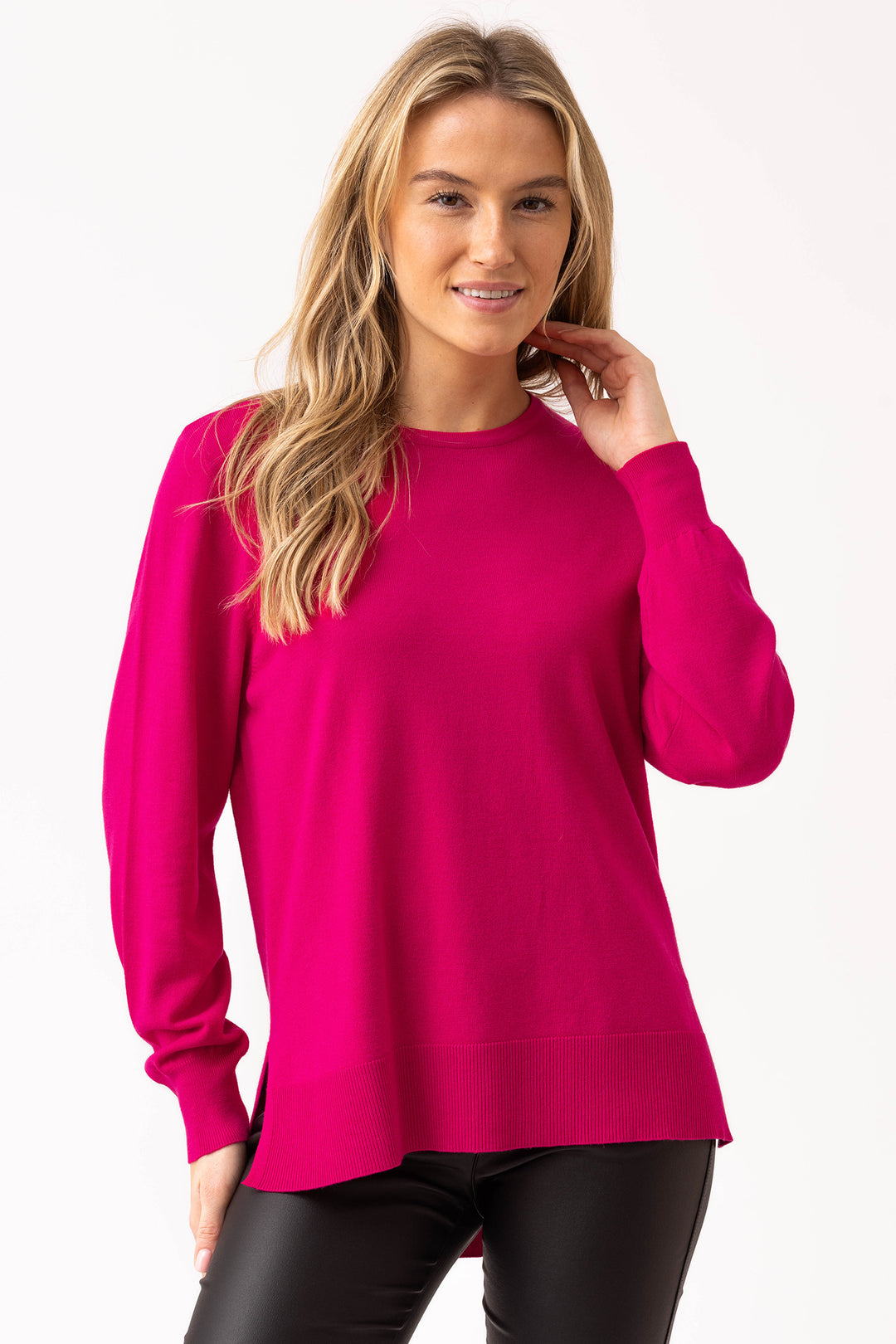 Woman wearing a bright pink sweater on a white background