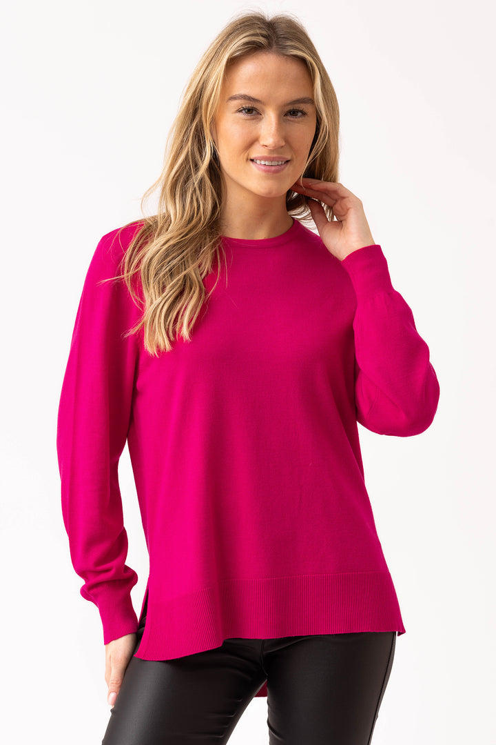 Woman wearing a bright pink sweater on a white background