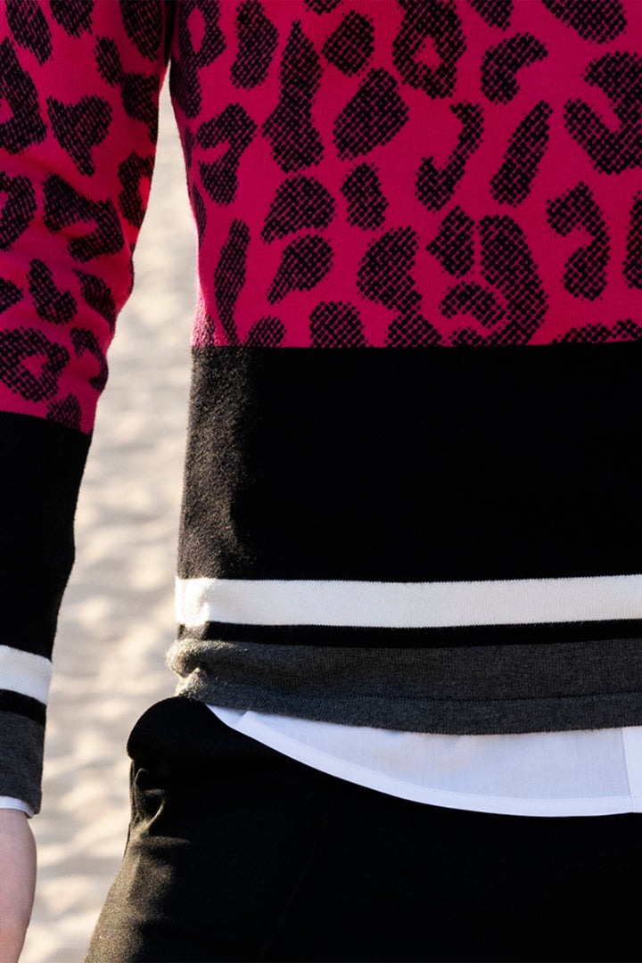 Close-up of a person wearing a red and black patterned top with a black and white striped shirt underneath.