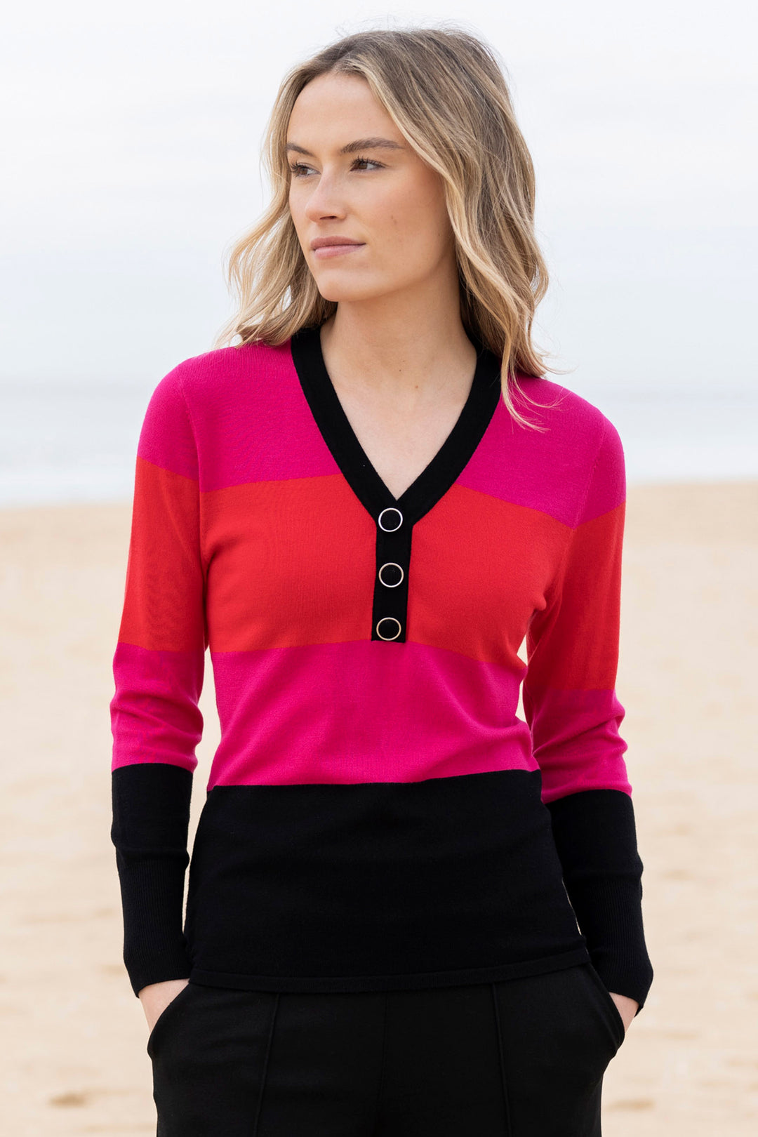 Woman wearing a colorful sweater with a beach background