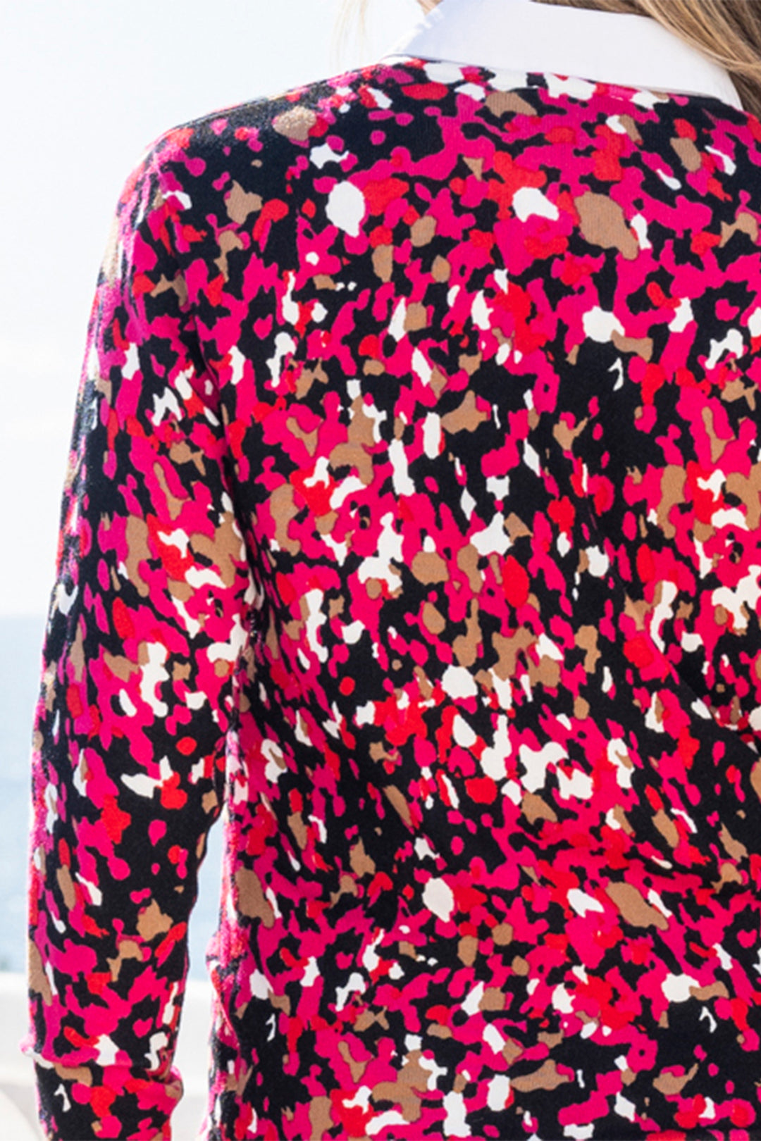 Close-up of a colorful patterned top with red, black, and white colors.