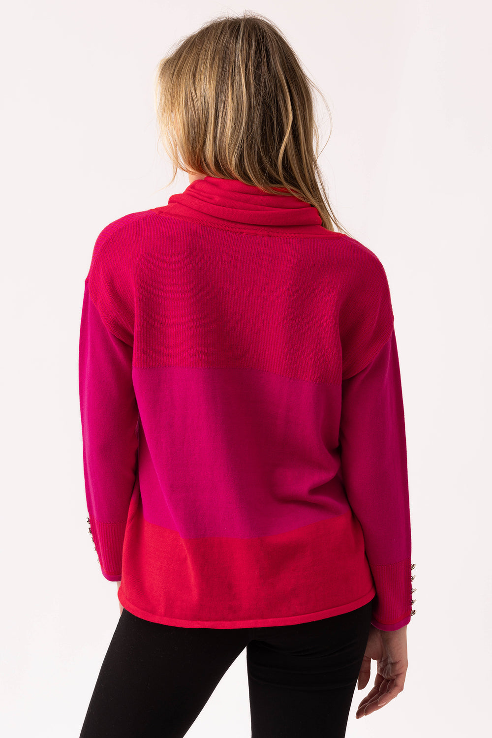Person wearing a bright pink sweater on a white background