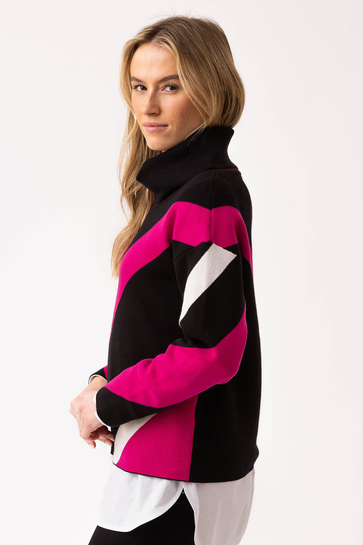 Woman wearing a black, pink, and white sweater on a white background