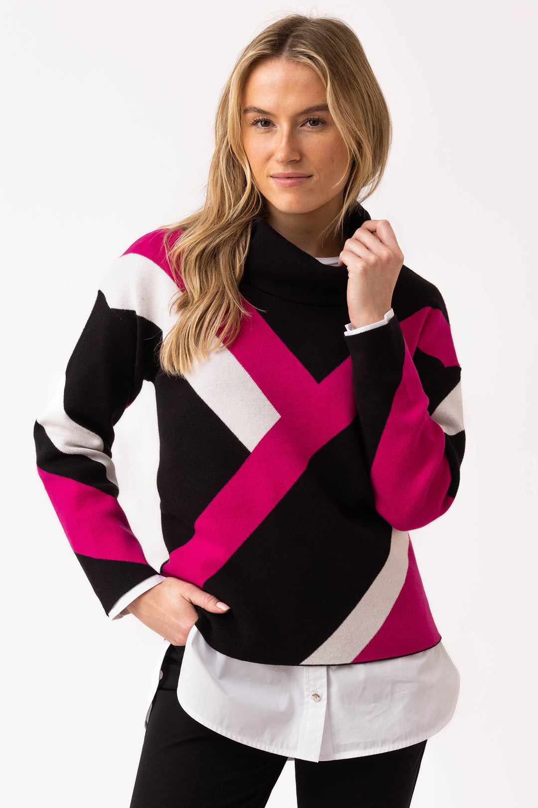 Woman wearing a colorful sweater with black, pink, and white pattern on a white background