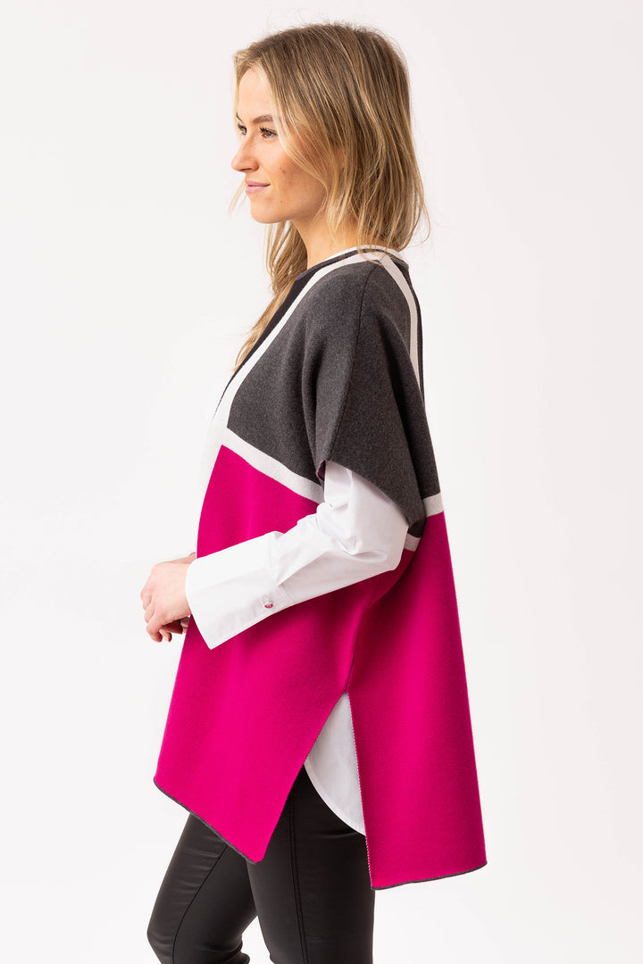 Woman wearing a pink and gray cardigan over a white shirt on a white background