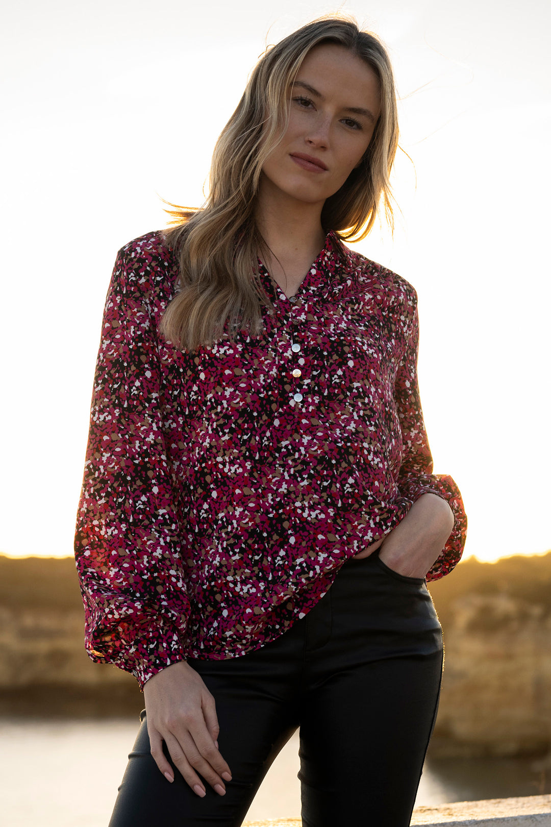 Woman wearing a floral blouse with a blurred natural background