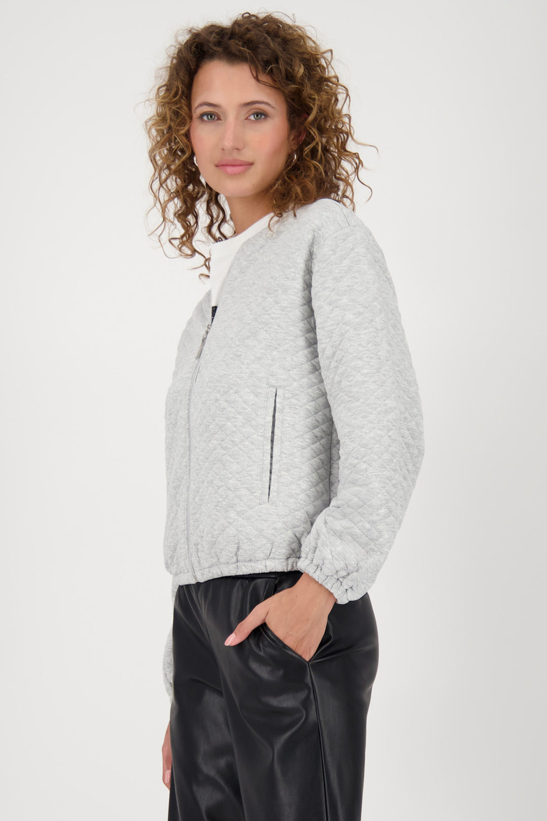 Woman wearing a light gray textured jacket on a white background