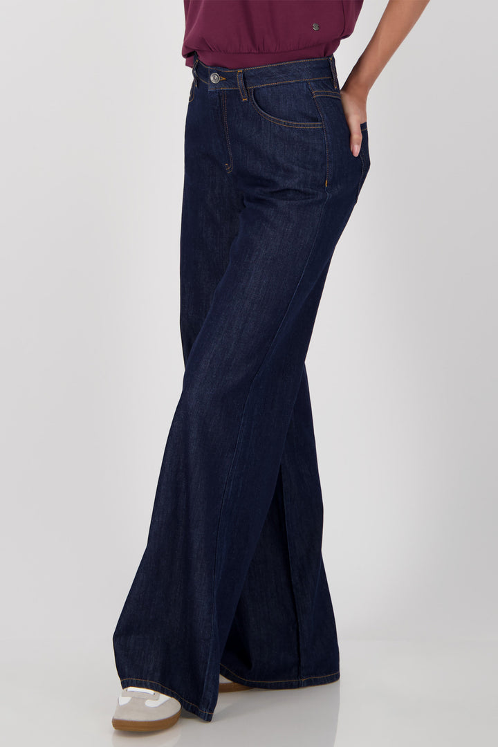 Navy wide-leg jeans worn by a person on a white background