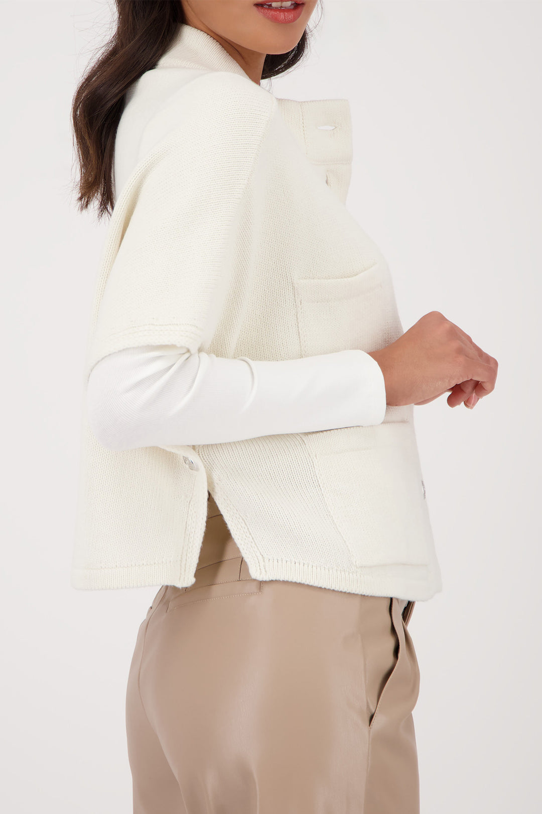Person wearing a white blazer and beige pants on a white background