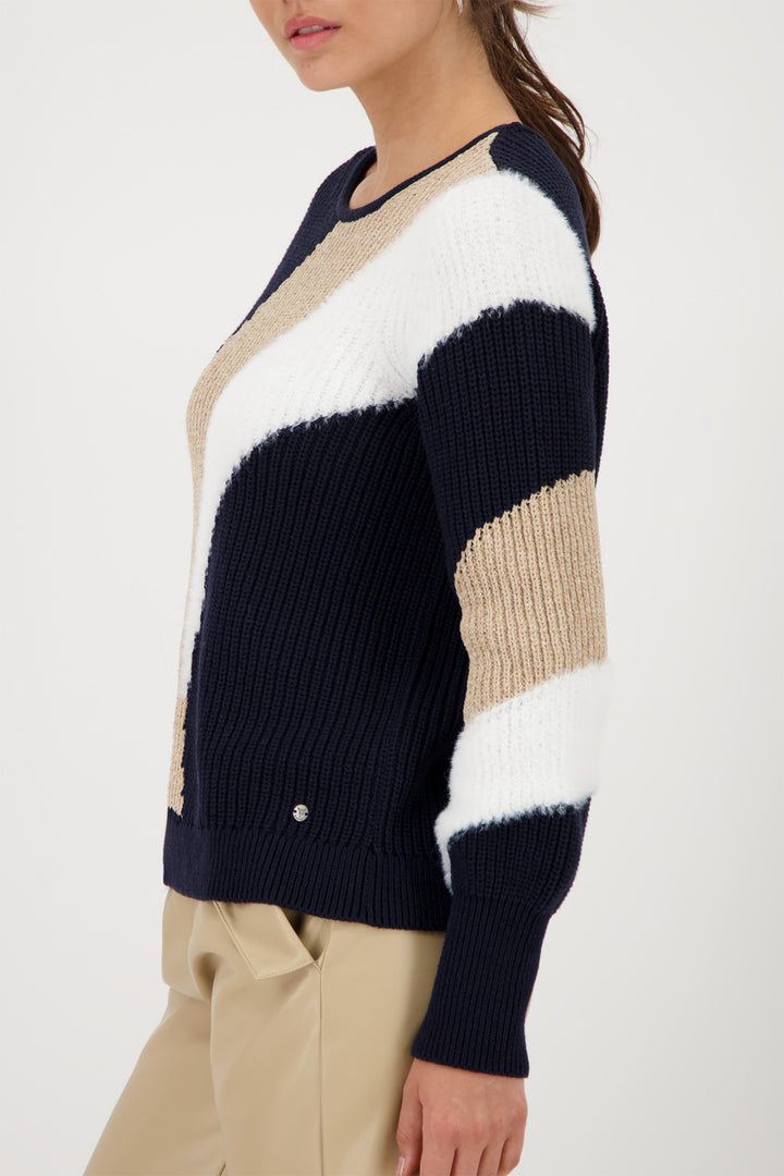 Color-blocked sweater with navy, beige, and white sections on a plain background