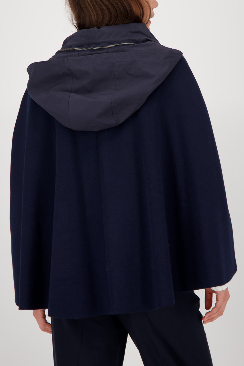 Navy blue hooded coat worn by a person on a white background