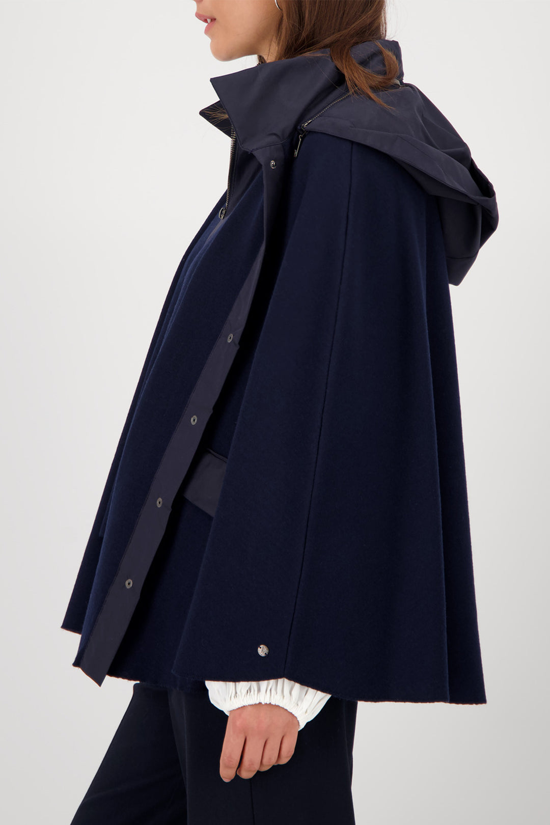 Navy raincoat with a hood worn by a person on a white background