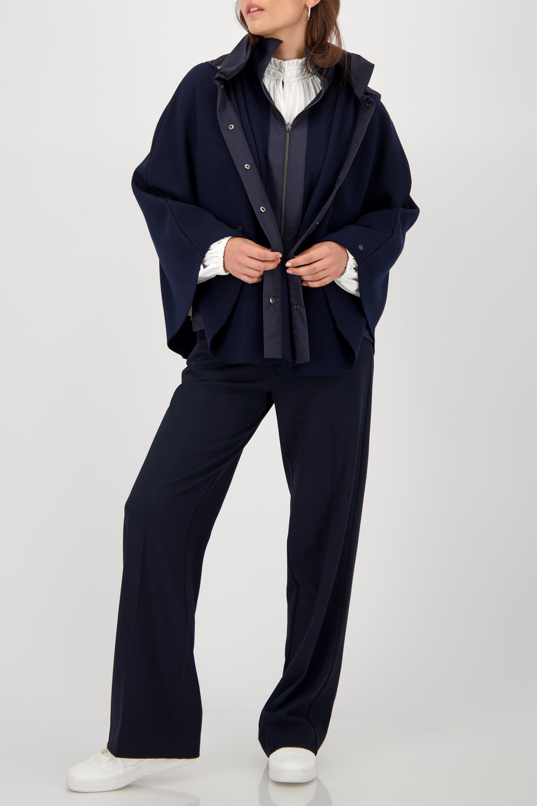 Person wearing a navy blue outfit with a white shirt on a white background