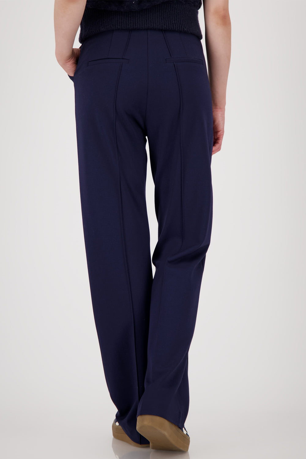 Navy blue pants worn by a person on a white background