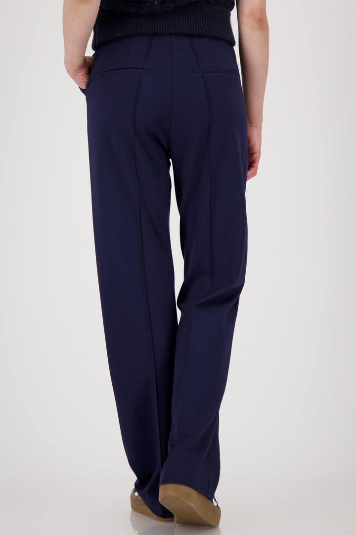 Navy blue pants worn by a person on a white background
