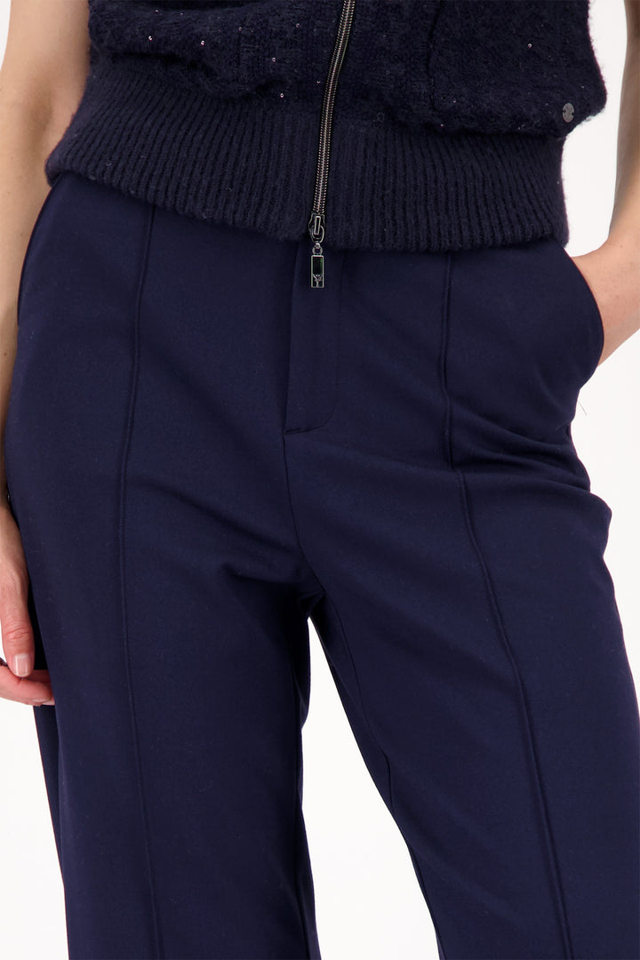Navy blue pants worn by a person on a white background