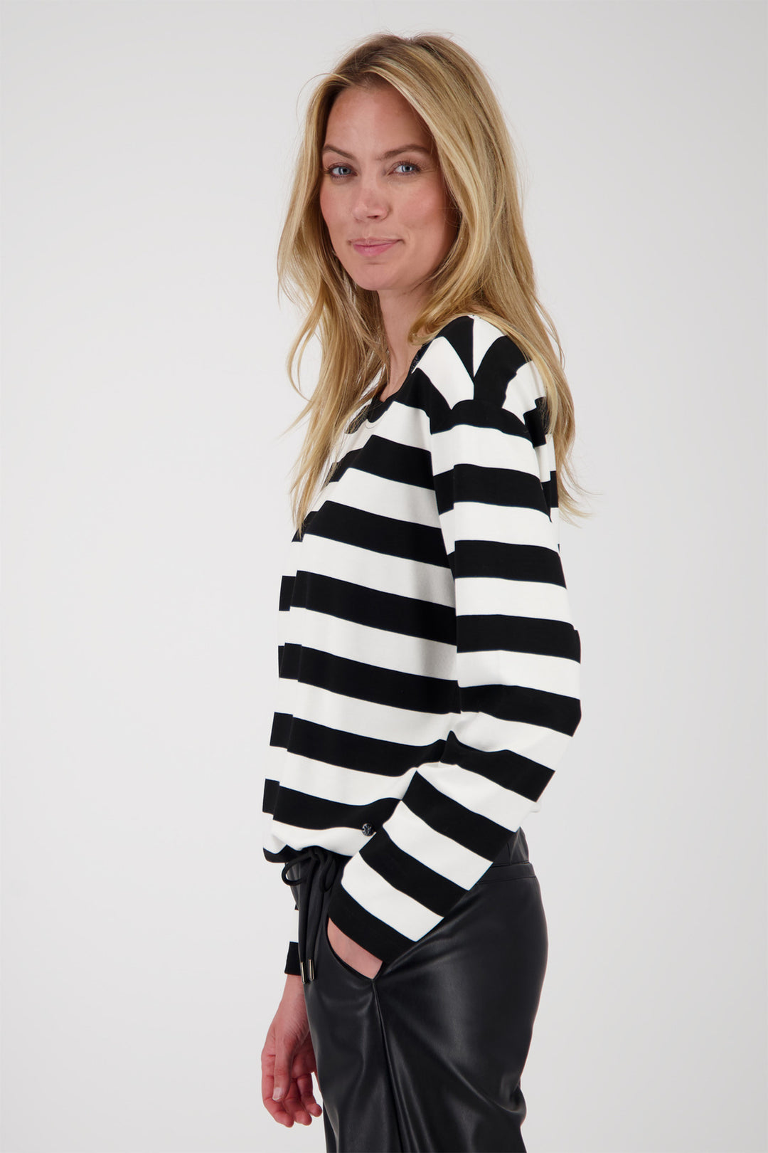 Woman wearing a black and white striped sweater against a plain background