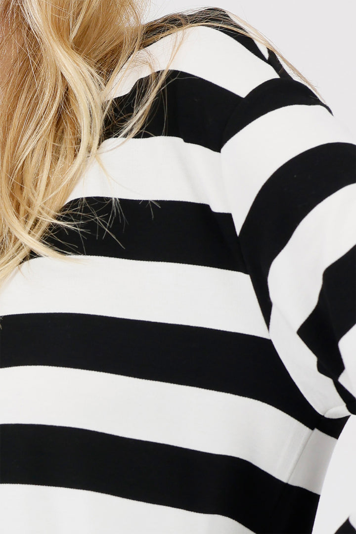 Close-up of a person wearing a black and white striped shirt.