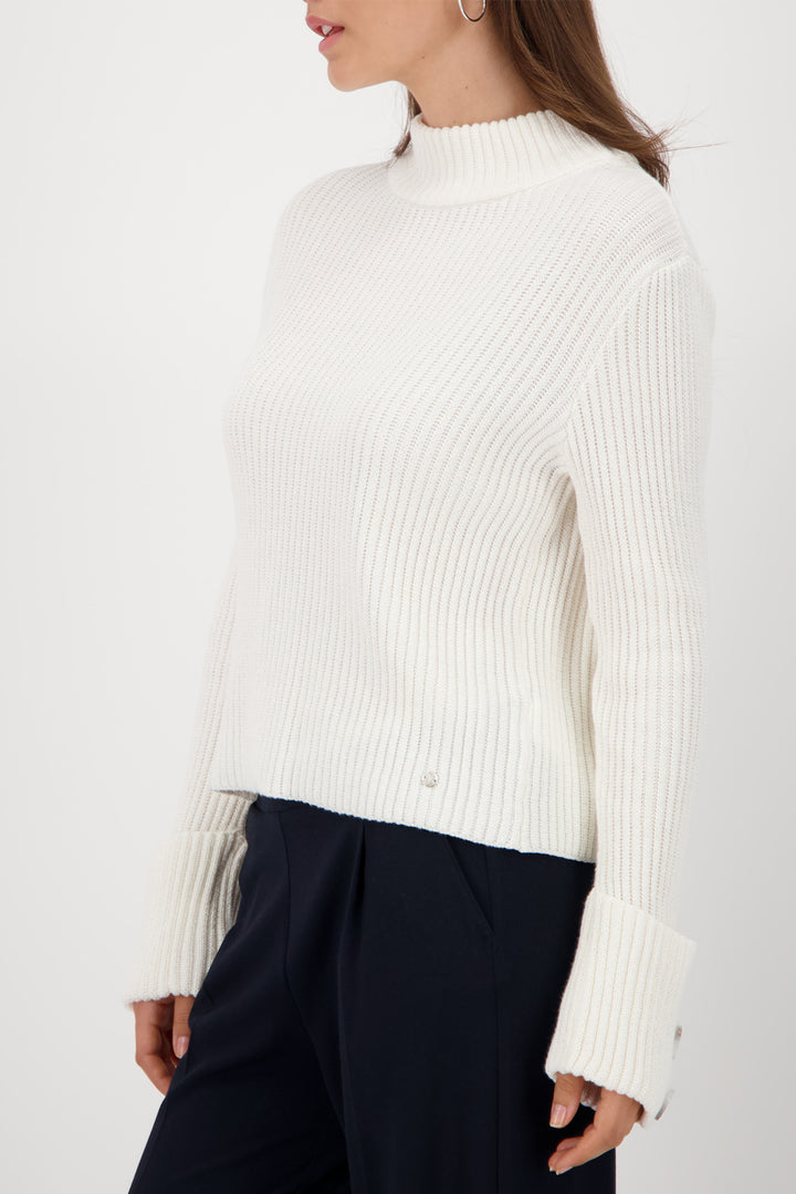 White ribbed sweater worn by a person on a white background