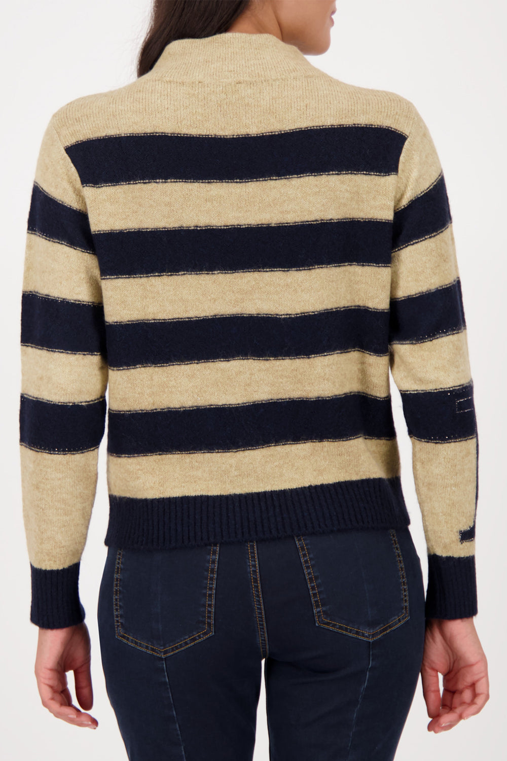 Beige and navy striped sweater worn by a person on a white background