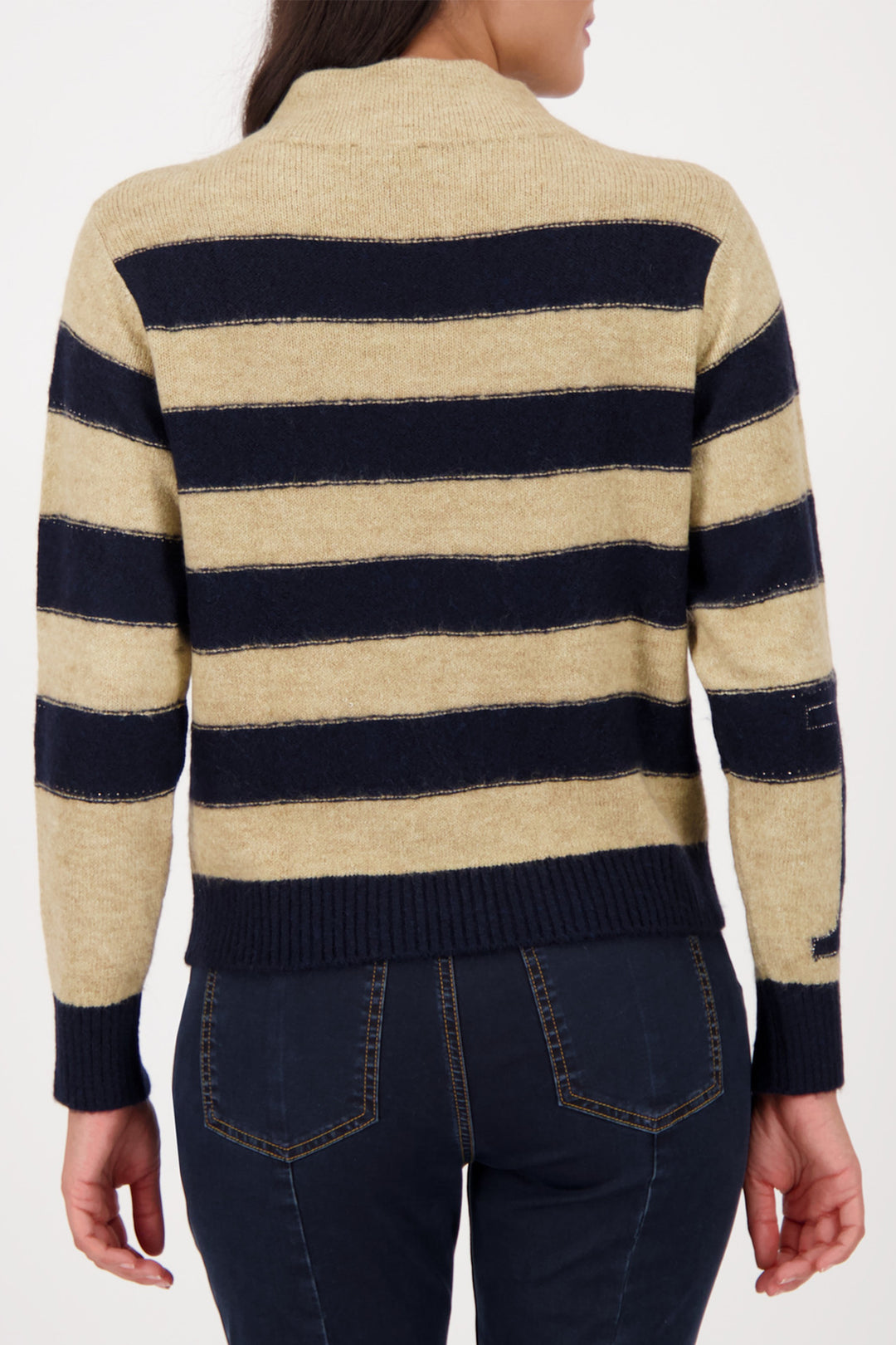 Beige and navy striped sweater worn by a person on a white background